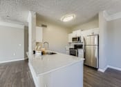 Thumbnail 10 of 32 - A kitchen with a white countertop and stainless steel appliances.