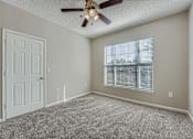 Thumbnail 9 of 32 - A room with a ceiling fan and a window with blinds.