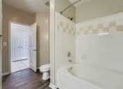Thumbnail 12 of 32 - A white bathroom with a tub, toilet and sink.