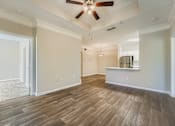 Thumbnail 3 of 32 - A room with a ceiling fan and wooden flooring.
