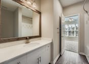 Thumbnail 4 of 32 - A bathroom with a sink, mirror, and bathtub.