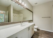 Thumbnail 6 of 32 - A bathroom with a white countertop and a white toilet.
