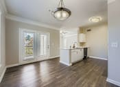 Thumbnail 31 of 32 - A kitchen area with a wooden floor and a ceiling light.
