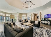 Thumbnail 23 of 32 - A modern living room with a large grey sofa and a chandelier.