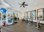 Thumbnail 22 of 32 - A spacious gym with a variety of exercise equipment and mirrors on the wall.