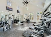 Thumbnail 17 of 32 - A spacious gym with treadmills, elliptical machines, and other exercise equipment.