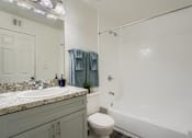 Thumbnail 11 of 37 - A bathroom with a toilet, sink, and shower.