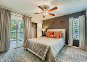 Thumbnail 4 of 37 - Bedroom with a bed, a ceiling fan, and a sliding glass door.