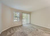 Thumbnail 23 of 37 - A room with a carpeted floor and a sliding glass door.
