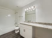 Thumbnail 19 of 37 - A white bathroom with a toilet, sink, and mirror.
