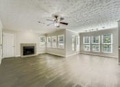 Thumbnail 21 of 37 - A spacious room with a fireplace and a ceiling fan.