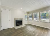 Thumbnail 25 of 37 - A room with a fireplace and a door.