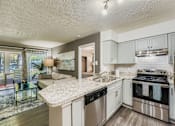 Thumbnail 1 of 37 - A modern kitchen with stainless steel appliances and a marble countertop.