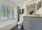 Thumbnail 10 of 37 - A white toilet sits next to a bathtub in a bathroom.