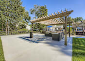 Thumbnail 27 of 37 - A playground with a wooden pergola and concrete structures.