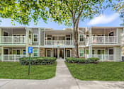 Thumbnail 31 of 37 - Apartment complex with a blue sign in front.