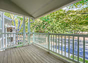 Thumbnail 32 of 37 - A white balcony with a wooden floor and a white railing.