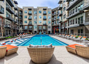 Thumbnail 28 of 35 - Resort-inspired pool area with clear water and surrounding lounge chairs.