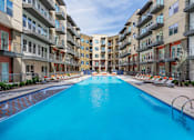 Thumbnail 29 of 35 - Resort-inspired pool area with clear water and surrounding lounge chairs.