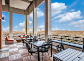 Thumbnail 34 of 35 - A patio with a table and chairs overlooking a desert landscape.