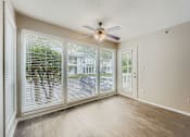 Thumbnail 18 of 39 - A room with a ceiling fan and sliding glass doors.