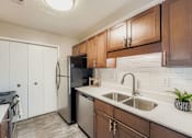 Thumbnail 35 of 39 - A kitchen with a black refrigerator and white cabinets.