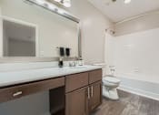 Thumbnail 14 of 39 - A white bathroom with a toilet, sink, and mirror.