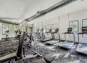 Thumbnail 20 of 39 - A gym with treadmills, exercise bikes, and other equipment.