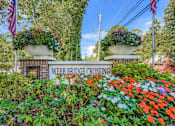 Thumbnail 29 of 39 - A sign that says Webb Bridge Crossing is surrounded by flowers.