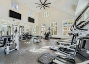 Thumbnail 17 of 32 - A gym with treadmills, weights, and exercise equipment.