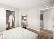 Thumbnail 9 of 28 - A bedroom with a bed, a closet, and a shelf.