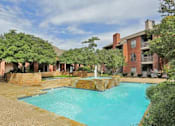 Thumbnail 36 of 38 - A large outdoor swimming pool surrounded by a brick wall and a fountain.
