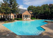 Thumbnail 37 of 38 - A swimming pool in a backyard with a patio and a small building.