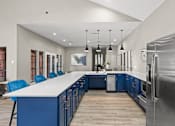 Thumbnail 13 of 38 - A modern kitchen with blue cabinets and a large island.