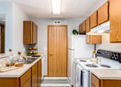 Thumbnail 28 of 40 - A kitchen with wooden cabinets and a white refrigerator.