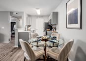 Thumbnail 3 of 28 - A modern kitchen with a glass dining table and chairs.
