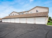 Thumbnail 24 of 28 - A large building with a garage door is in the foreground.