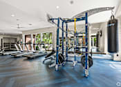 Thumbnail 19 of 38 - A gym with a variety of equipment including a punching bag.