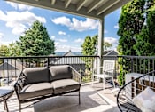 Thumbnail 14 of 26 - A patio with a couch, chair, and table with a view of the mountains.