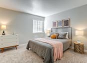 Thumbnail 12 of 26 - A bedroom with a bed, nightstand, and dresser.