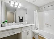 Thumbnail 9 of 39 - A white bathroom with a toilet, sink, and mirror.