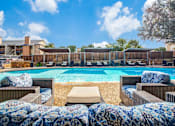 Thumbnail 3 of 20 - A pool surrounded by chairs with a blue and white blanket.