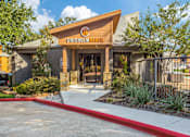 Thumbnail 16 of 20 - The Chisholm Ranch building has a wooden entrance with a red walkway leading to it.