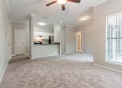 Thumbnail 34 of 38 - A spacious living room with a carpeted floor and a ceiling fan.