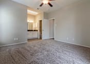 Thumbnail 26 of 38 - A room with a carpeted floor and a ceiling fan.