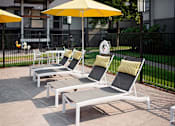 Thumbnail 16 of 24 - A set of outdoor furniture including chairs and a table is arranged on a patio.