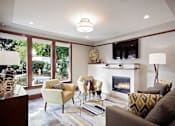 Thumbnail 19 of 24 - A living room with a fireplace and a couch.