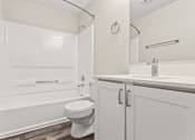 Thumbnail 7 of 24 - A white toilet sits in a bathroom next to a sink.