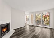 Thumbnail 9 of 24 - A room with a fireplace and a view of a tree outside.