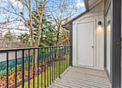 Thumbnail 14 of 24 - A balcony with a white door and a black railing.